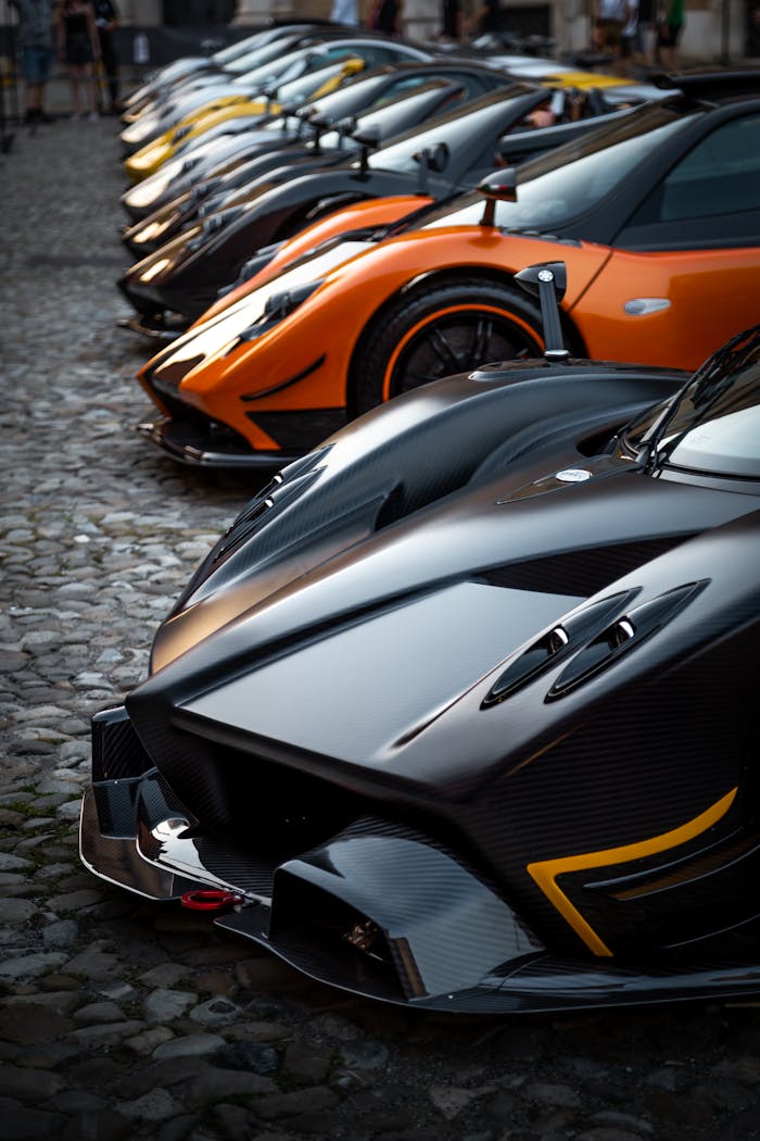 A stunning lineup of luxury hypercars displayed outdoors, showcasing sleek designs and vibrant colors.